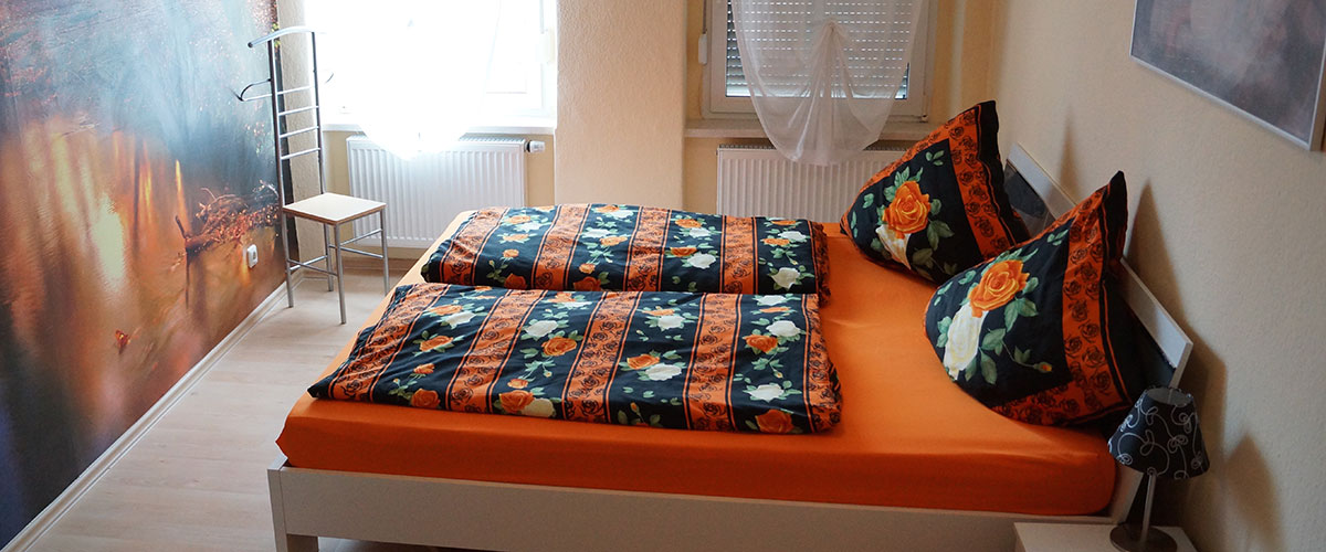 Schlafstube der Ferienwohnung mit Doppelbett und Fenster