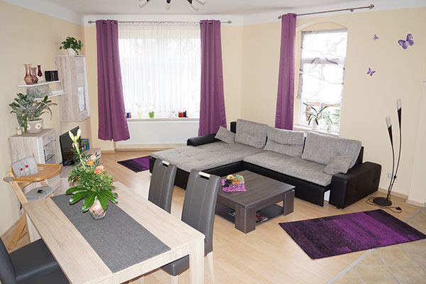 Heller Wohnbereich der Ferienwohnung mit Sitzgruppe und Esstisch